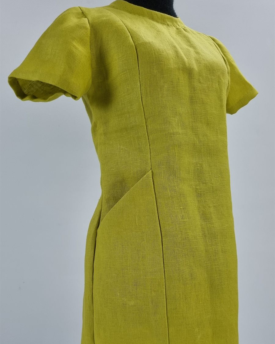 Vestido de lino verde con pinzas, sobre maniquí