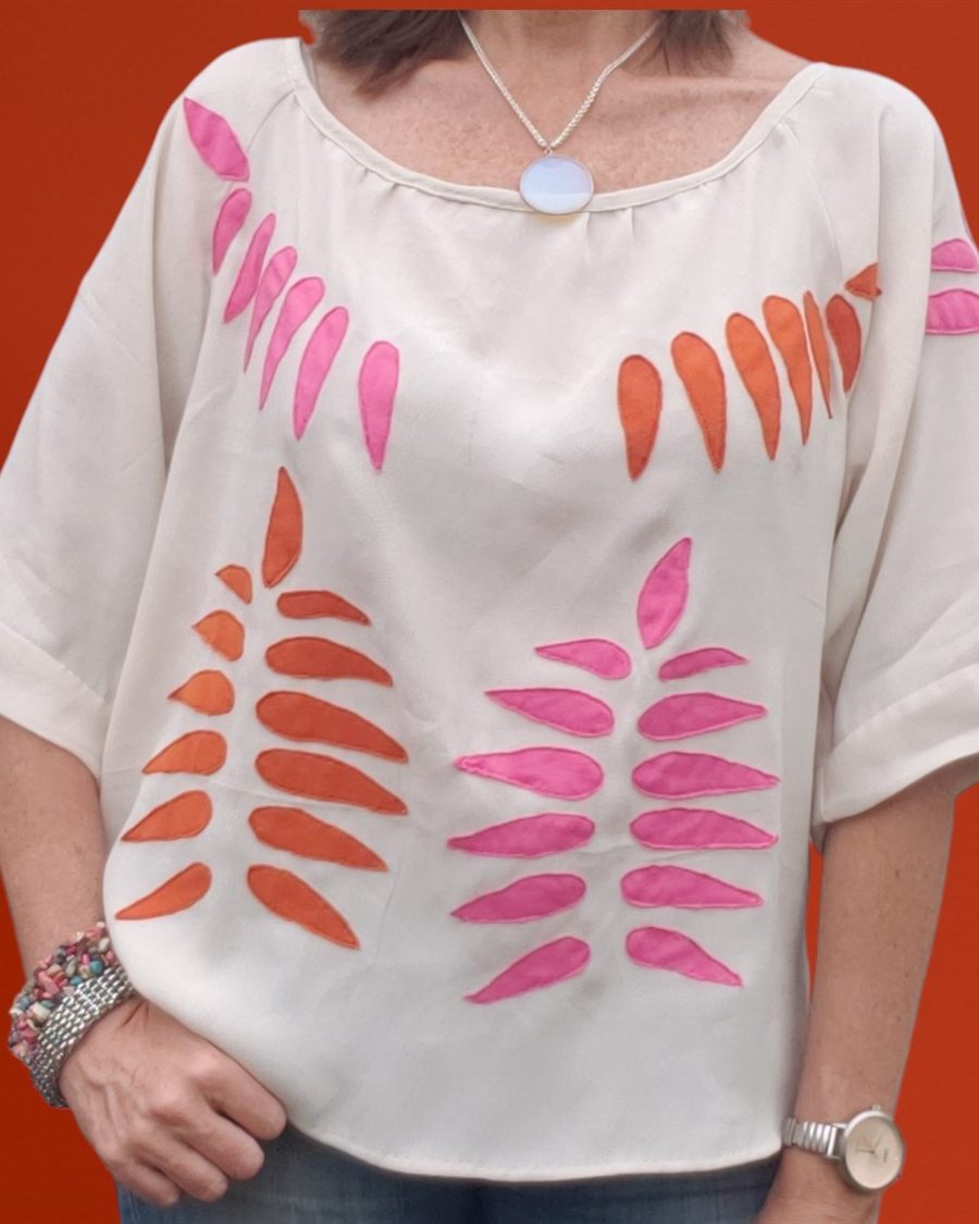 Blusa crema con apliques en rosa y naranja